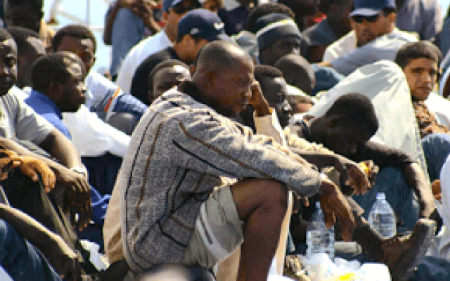 Uomo Di Colore Migrante, Seduto I Nattesa Di Soccorso