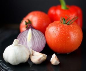 Piatto con aglio, cipolla, pomodori e peperone.