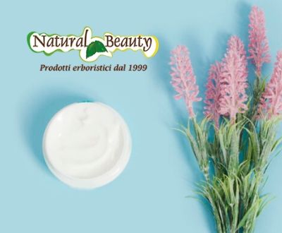 Vasetto di crema naturale viso dall'alto su sfondo azzurro con di fianco un fiore rosa